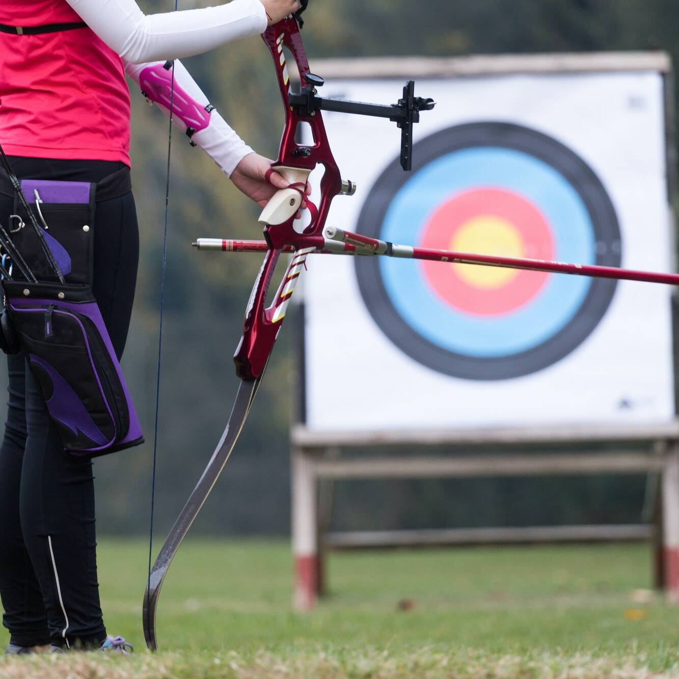 Female athlete practicing archery in stadium