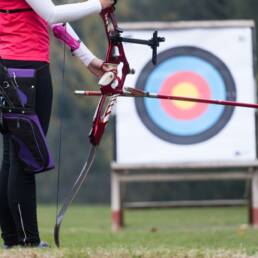 Female athlete practicing archery in stadium