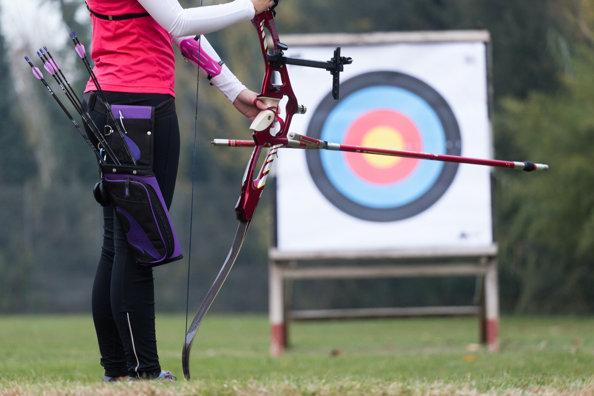 Female athlete practicing archery in stadium