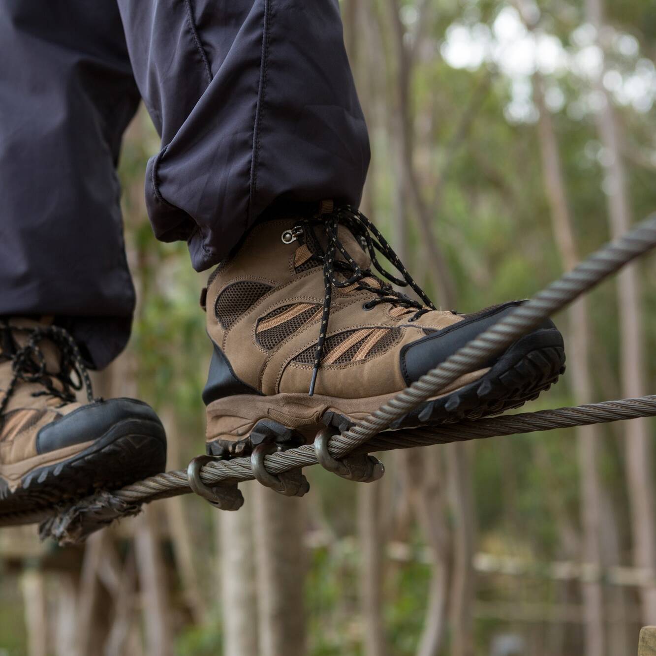 Hiker foot walking on zip line cable in the forest